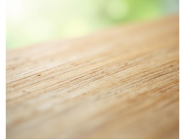 Close-up of beautiful, responsibly sourced light-colored wood grain with a subtle green tint, symbolizing sustainability.